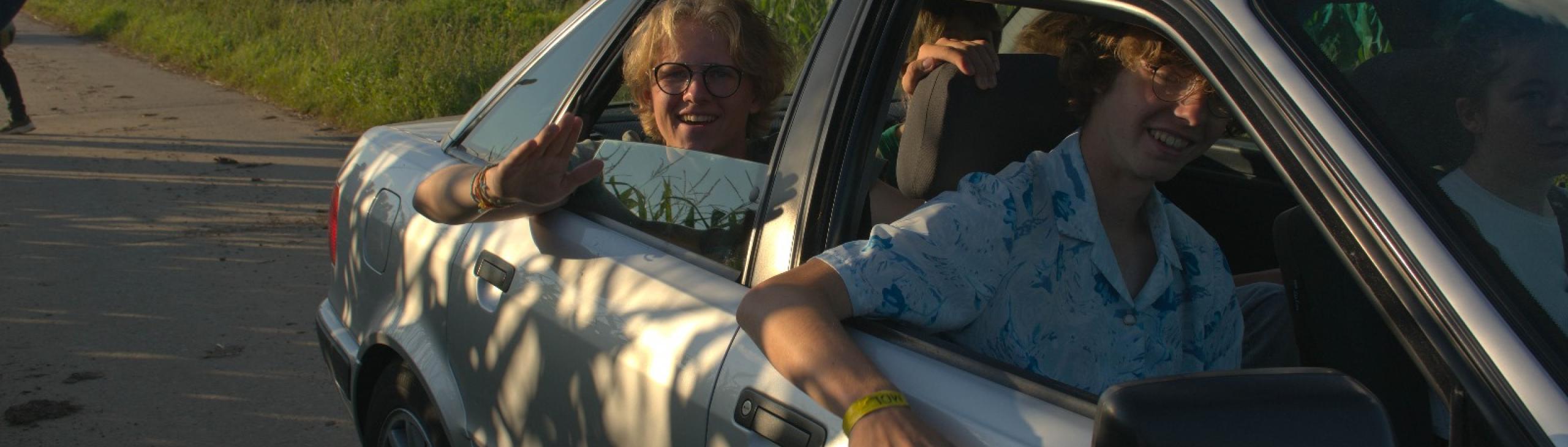 Jongeren in auto met zonlicht